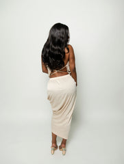 Woman wearing a beige dress with cut-out details on a white background